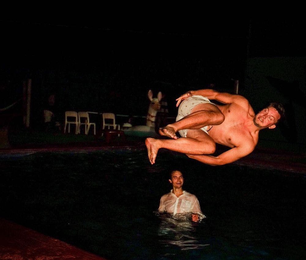 Kollega som hopper i bassenget på nattestid i Barcelona