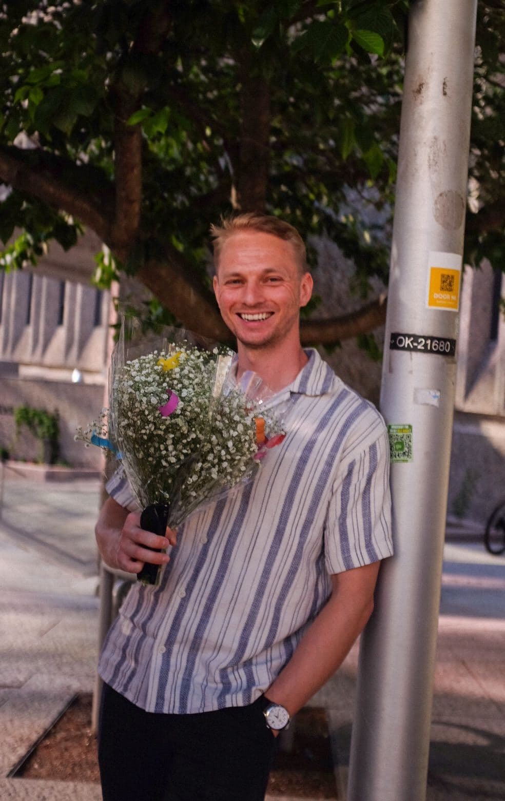 Smilende kollega med blomsterbukett